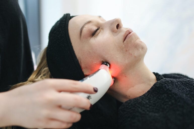 microcurrent cihazla yüz bakımı yapan kadın