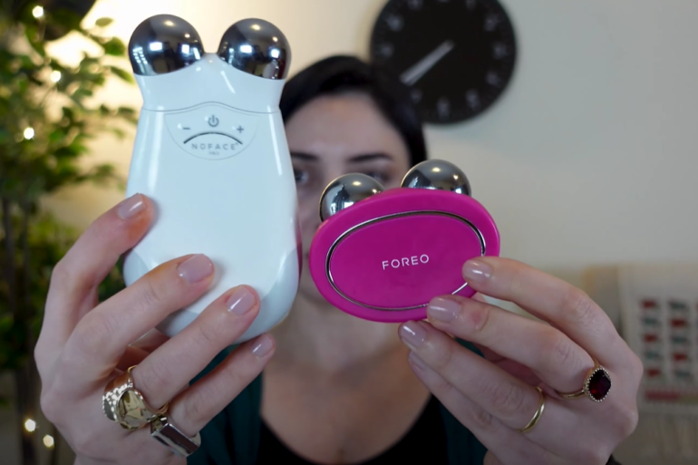 A woman holding the Foreo BEAR device